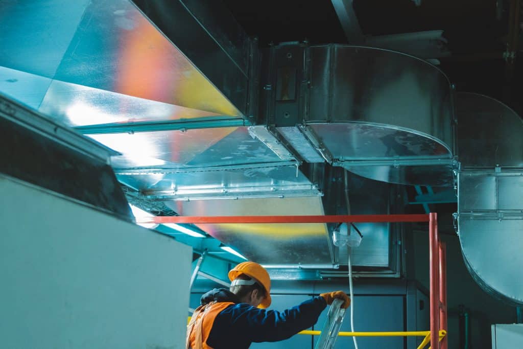 Young,Man,In,Orange,Work,Vest,,Safety,Belt,And,Hard a man using ladders to implement fire stopping services from element pfp