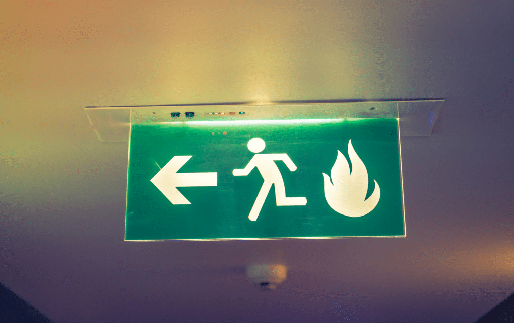 A clear and lit-up fire exit sign pointing to the left