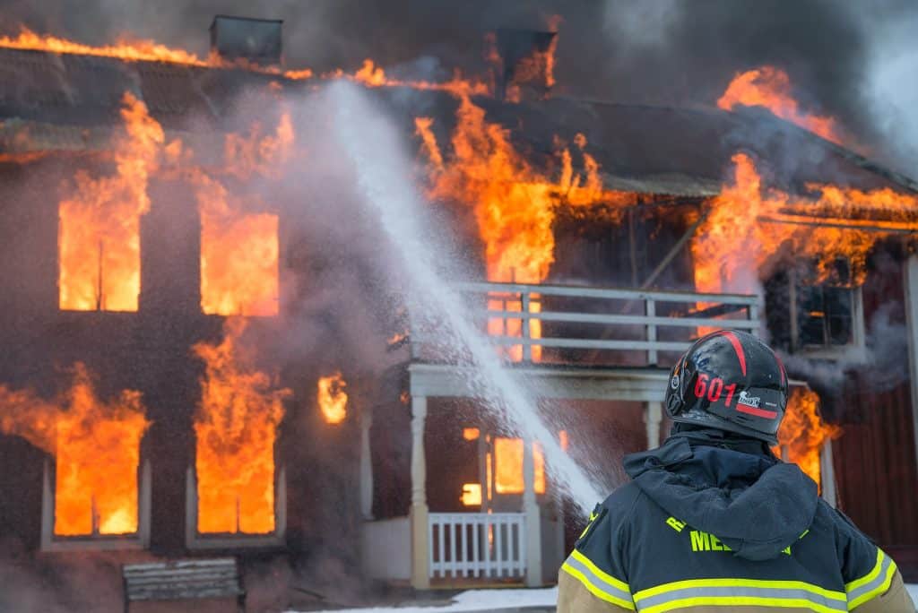 A fireman putting out a large property fire